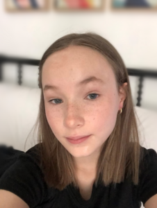 Lily Sander, girl with auburn hair and freckles, wearing a black t-shirt